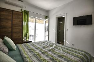a bedroom with a large bed and a television at Rooms DRAGICA in Pakoštane
