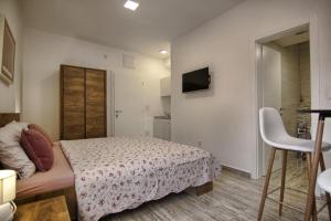 a small bedroom with a bed and a chair at Rooms DRAGICA in Pakoštane