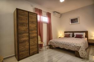 a bedroom with a bed and a large wooden closet at Rooms DRAGICA in Pakoštane