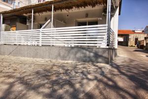 a white fence on the side of a house at Rooms DRAGICA in Pakoštane
