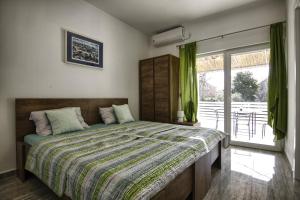 a bedroom with a large bed with green curtains at Rooms DRAGICA in Pakoštane