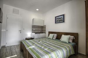 a bedroom with a bed and a white wall at Rooms DRAGICA in Pakoštane