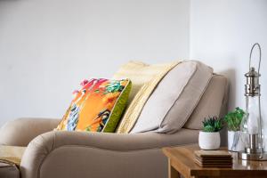 a living room with a couch with a pillow on it at Westward 14 Polzeath in Polzeath +23 photos