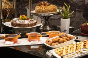 a buffet with various pastries and desserts on a table at Saint Emilion by Atlantica in Curitiba