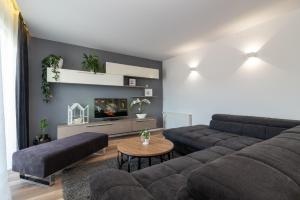 sala de estar con sofá y TV en Apartman Tragos, en Trogir