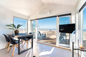 ein Esszimmer mit Blick auf den Strand in der Unterkunft BUDDHA BEACH BUNGALOWS Adults Only in Zandvoort
