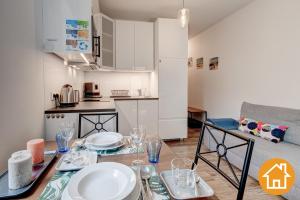 a living room with a table and a kitchen at Apartamenty Leśne - visitopl in Świnoujście