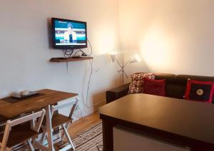 sala de estar con sofá y TV en la pared en Letterkenny Town Centre Apartment, en Letterkenny
