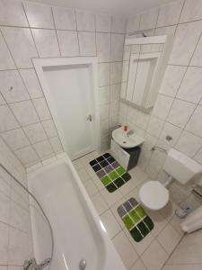 biała łazienka z wanną i toaletą w obiekcie Ferienwohnung Schloßstraße w Essen