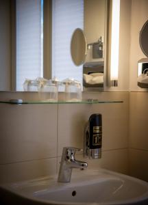 a bathroom with a sink and a glass shelf above it at Wertheimer Stuben in Wertheim