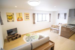 - un salon avec un canapé et une télévision dans l'établissement 渡 - Duo Okinawa, à Onna