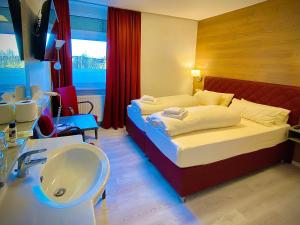 ein Hotelzimmer mit einem Bett und einem Waschbecken in der Unterkunft Meister BÄR HOTEL Frankenwald in Berg