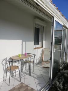 a patio with a table and chairs on a balcony at Maison à 100 m de la plage à St Hilaire de Riez in Saint-Hilaire-de-Riez +18 photos