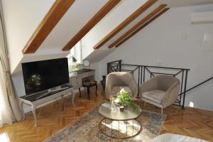 sala de estar con TV, 2 sillas y mesa en Merla Art & Luxury Rooms, en Split