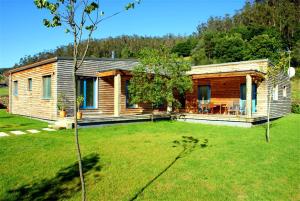 a log cabin in a yard with a green lawn at A Cabana de Carmen in Cabana Moura 