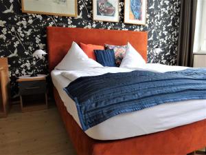 a bed with a blue comforter and pillows at Pension Zur Fährbrücke in Stralsund