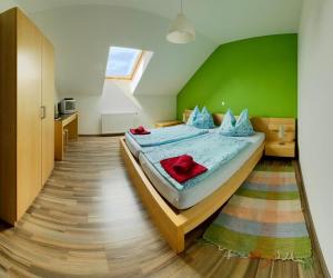 a bedroom with a bed with a green wall at Pension Rohrwald in Oberrohrbach
