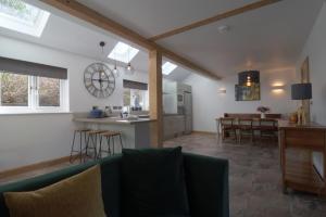 sala de estar y cocina con sofá y mesa en The Hayloft en Redlynch