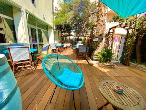 a blue rattan chair sitting on a wooden deck at Hotel Les Grenadines in Cap d'Agde