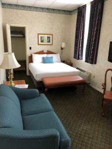 une chambre d'hôtel avec un lit et un canapé dans l'établissement Stearns Hotel, à Ludington