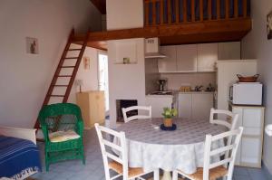 a kitchen and dining room with a table and chairs at Petite maison reposante pour 2 au bord de mer in Brétignolles-sur-Mer