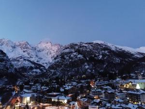 a city with snow covered mountains in the background at Hotel Walser Courmayeur in Courmayeur