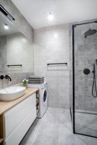 ein Badezimmer mit einem Waschbecken und einer Waschmaschine in der Unterkunft Sailor Apartament Nadmorski 30 in Ustronie Morskie