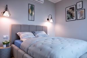 ein Schlafzimmer mit einem großen blauen Bett mit zwei Kissen in der Unterkunft Sailor Apartament Nadmorski 30 in Ustronie Morskie