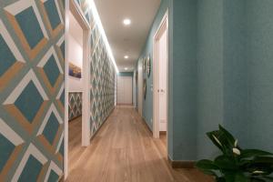 a hallway with blue walls and wooden floors at Napolilive B&B in Naples