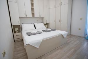 Apartment Toni في ماكارسكا: غرفة نوم بسرير ابيض عليها منشفتين