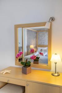 Blue Harmony Hotel في كينيون: غرفة نوم مع سرير ومكتب مع مرآة