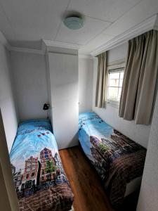 a bedroom with two twin beds and a window at Giet Oan gelegen op Resort Venetië in Giethoorn