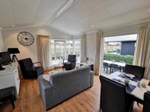 a living room with a couch and a table and chairs at Giet Oan gelegen op Resort Venetië in Giethoorn