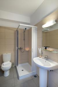 a bathroom with a shower and a toilet and a sink at Blue Harmony Hotel in Kini