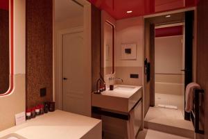 a bathroom with a sink, toilet, and bathtub at Sinner Paris in Paris