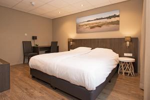 Un pat sau paturi într-o cameră la Fletcher Hotel Restaurant Prinsen
