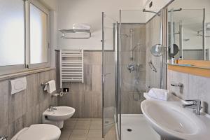 a bathroom with a sink and a toilet and a shower at Aregai Marina Hotel & Residence in Santo Stefano al Mare +65 photos