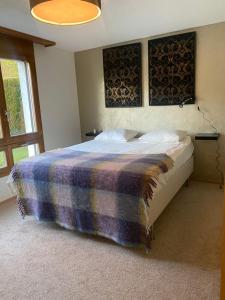 um quarto com uma cama com um cobertor em Luxury family apartment Engelberg em Engelberg