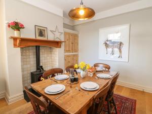 a dining room with a wooden table and a fireplace at Number 15 in Thirsk