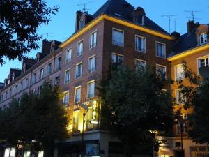 a large brick building on a city street at Logis Hôtel Marguerite in Orléans