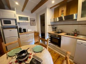 uma cozinha com uma mesa e uma cozinha com um fogão em Le REFUGE véritable cocon avec Cheminée em Les Orres