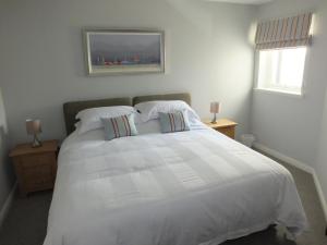 a bedroom with a large white bed with two pillows at Luxury Riverbank Apartment, Nairn in Nairn