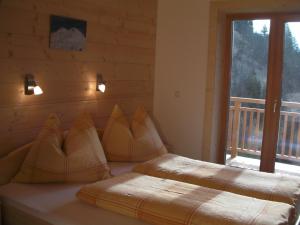2 Betten in einem Zimmer mit Fenster in der Unterkunft Chalet Rasnerhof in Hopfgarten in Defereggen