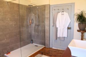 a bathroom with a shower with a glass door at L'Ancienne Ecole in Vernassal