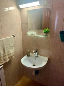 W łazience znajduje się umywalka i lustro. w obiekcie Dorottya Vendégház w Miskolc-Tapolca