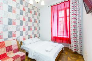 1 dormitorio con 1 cama y una ventana con cortinas rojas en Квартира на вулиці Краківській 34, en Leópolis