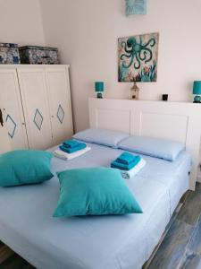 2 letti in una camera con cuscini blu di Maison Turquoise a Cala Gonone