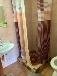y baño con ducha y lavamanos. en Dorottya Vendégház, en Miskolctapolca
