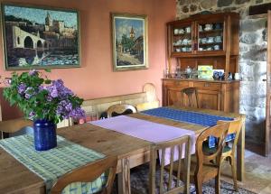 a dining room with a wooden table with flowers on it at L'Ancienne Ecole in Vernassal