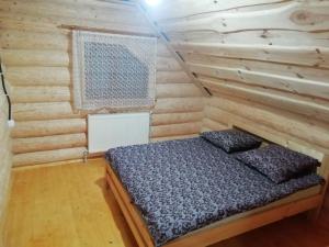 a bedroom with a bed in a wooden cabin at VanMarri in Vyshka
